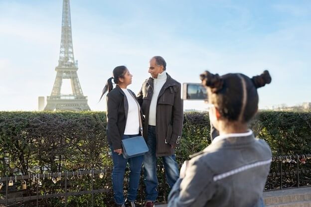 Child taking picture of parents at the eiffel tower