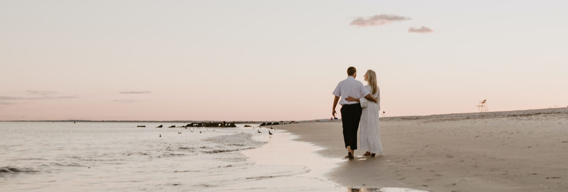 couple walking on the beach in the sunset